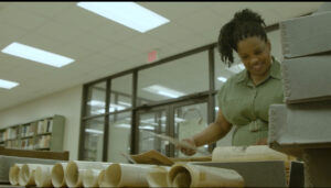 Professor Kimberly Monroe sifting through historical documents in a library
